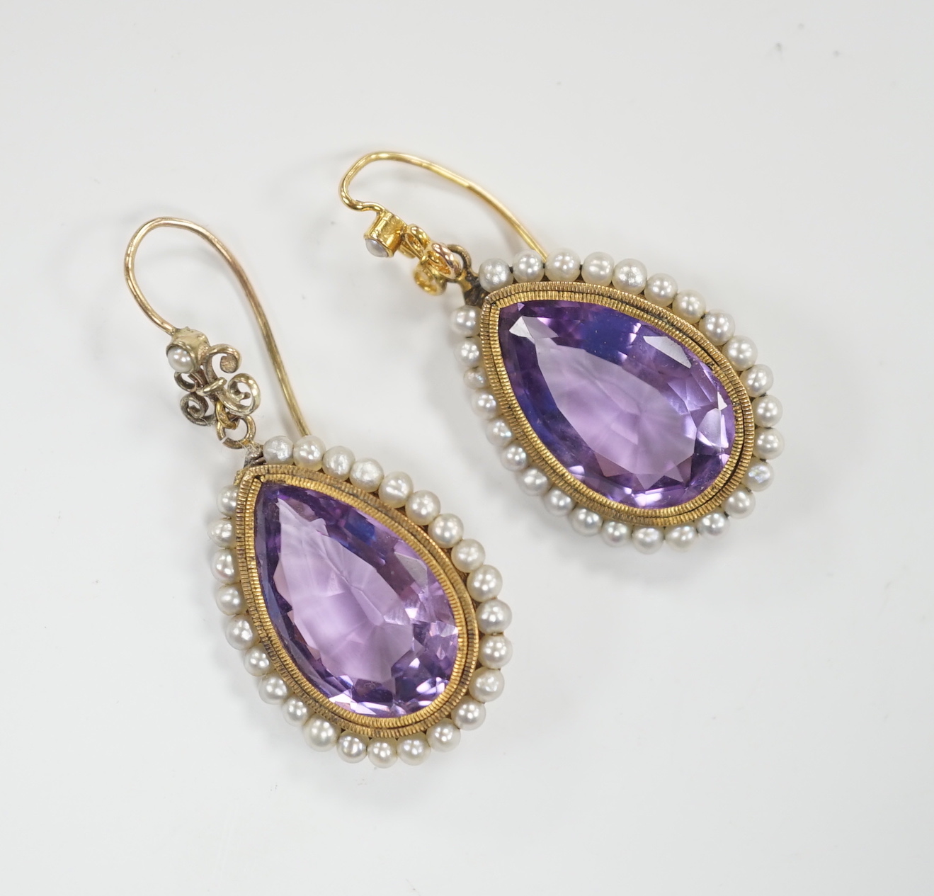 A pair of Victorian yellow metal, amethyst and seed pearl set teardrop shaped drop earrings, 21mm, gross weight 5.5 grams.